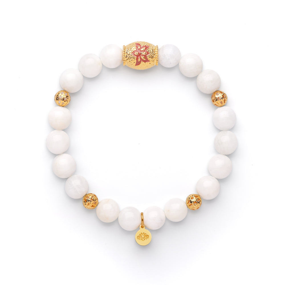 A bracelet with white beads and gold accents, featuring a gold beaded chain and a lotus flower charm, displayed against a white background.