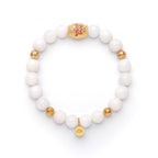 A bracelet with white beads and gold accents, featuring a gold beaded chain and a lotus flower charm, displayed against a white background.