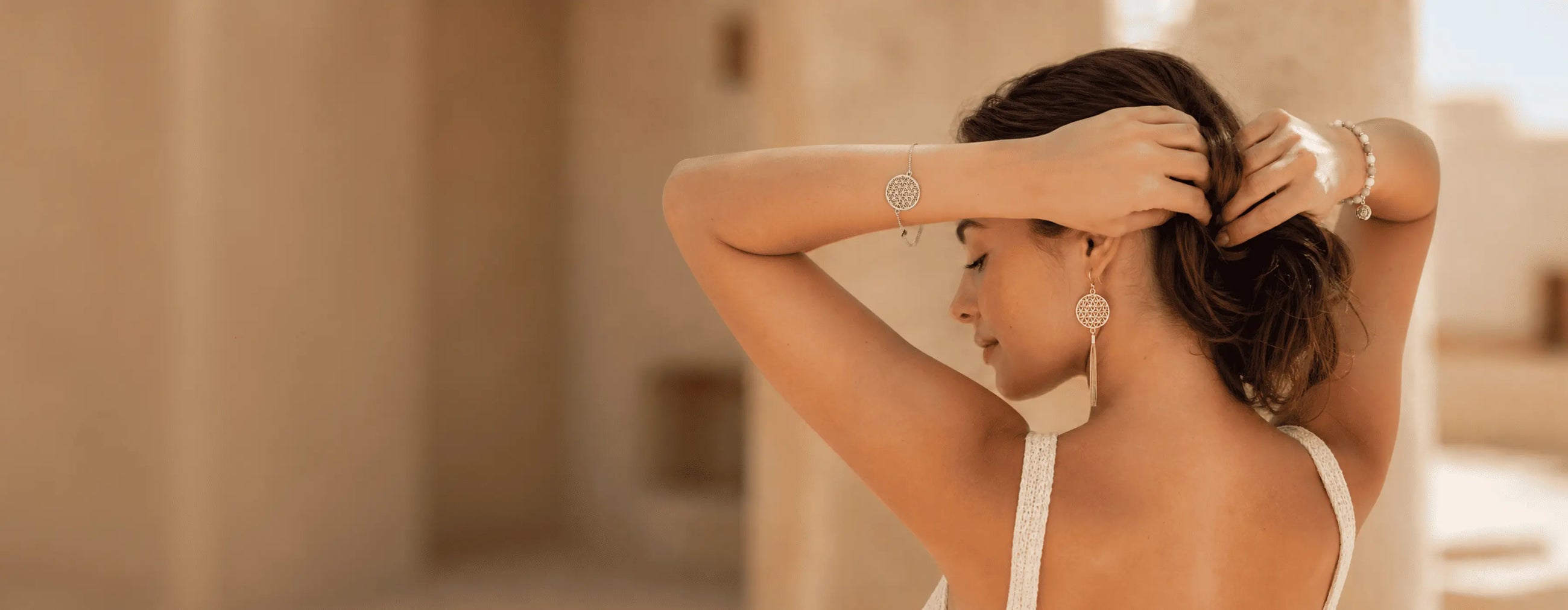 Woman adjusting her hair in a warm-toned setting